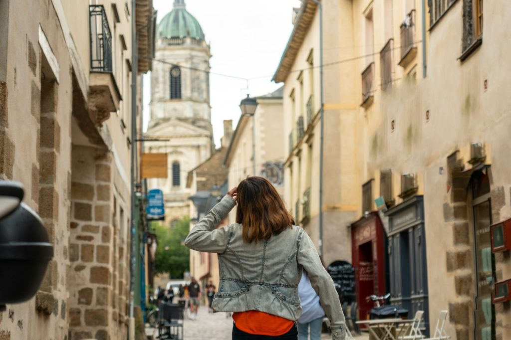 A young tourist at the medieval half-timbered houses in Rennes. Capital of Brittany, France