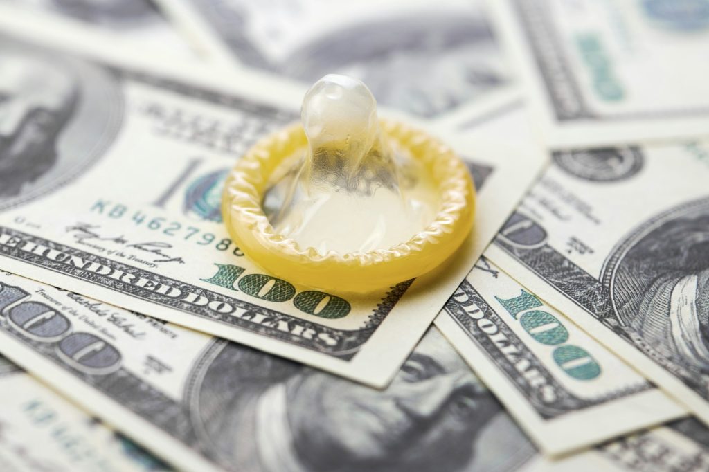 Condom on dollars bills
