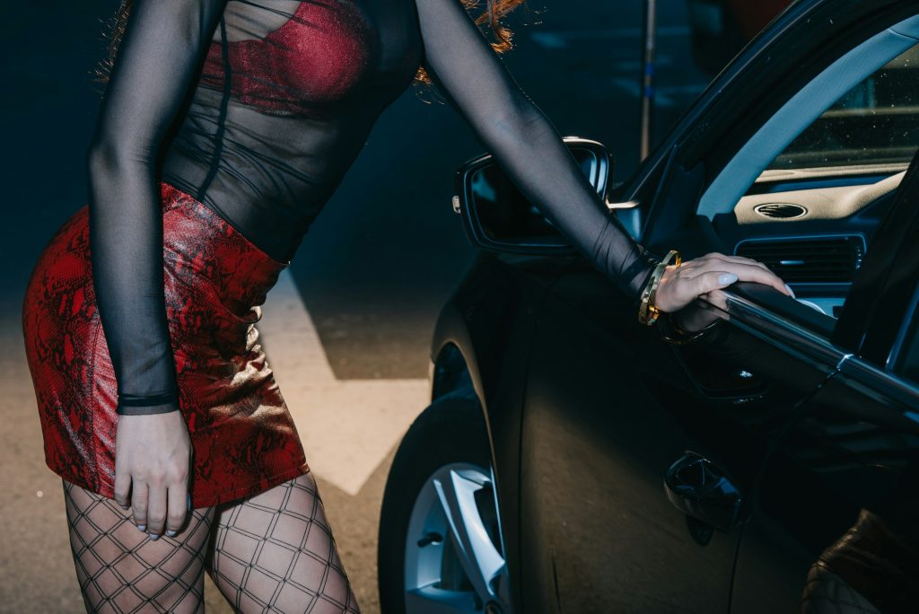 cropped view of prostitute standing near modern car