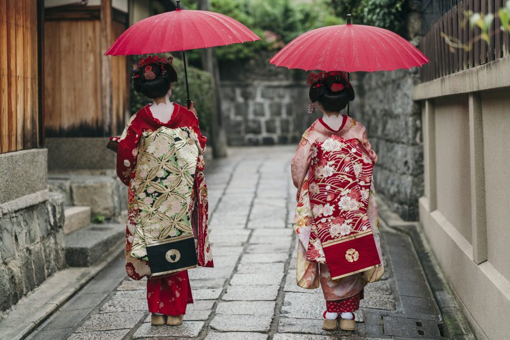 Maiko geishas walking on a street of Gion
