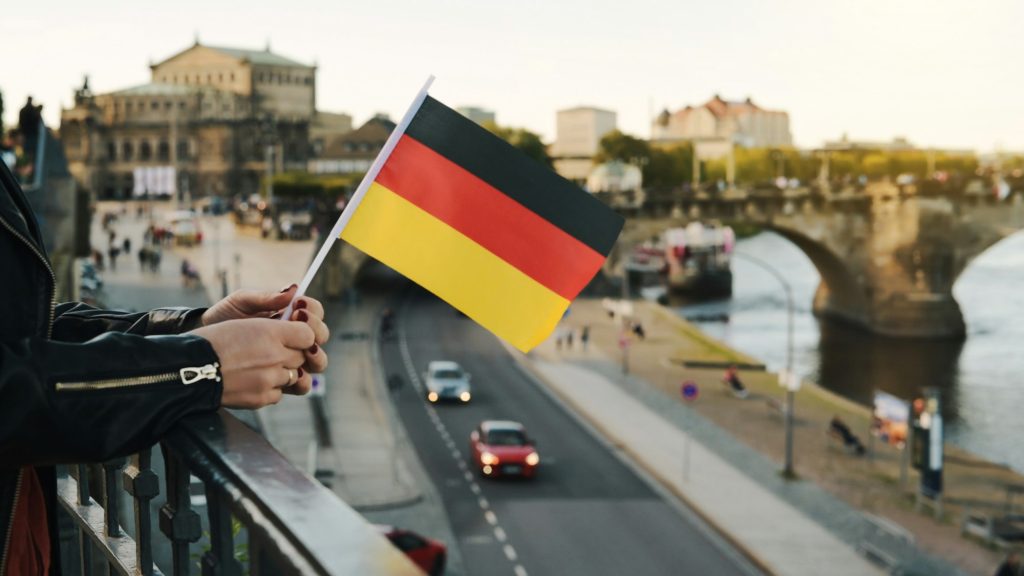 Young Woman Holds German Flag In Hand