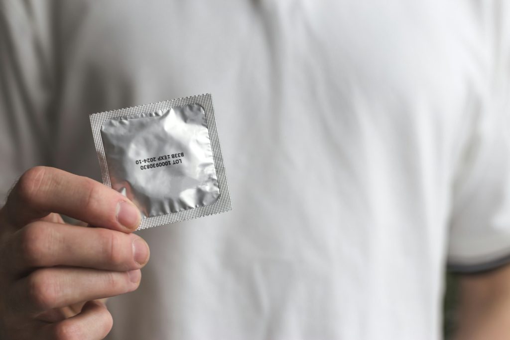 Male hand holding condom.